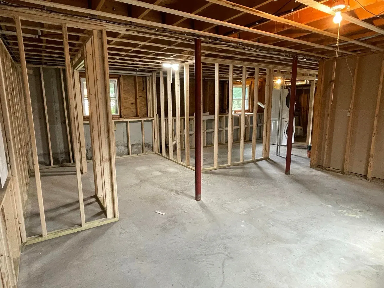 New wood-frame partition walls and steel posts inside a renovation before drywall goes up